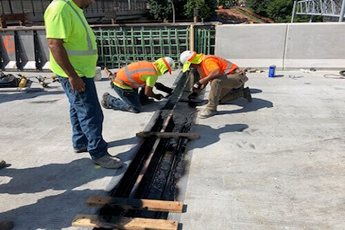 3 people working on construction at LaGuardia Airport